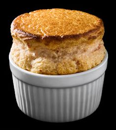 a close up of a pastry in a white bowl on a black background with one piece missing