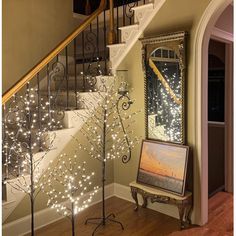 the stairs are decorated with christmas lights, and there is an easel next to it