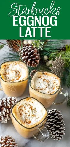 two mugs filled with eggnog latte next to pine cones