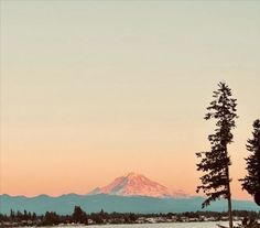 the sun is setting over a lake with mountains in the background