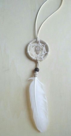 a white feather is attached to a necklace