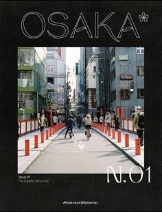 an image of people riding bikes on the street with orange barricades and buildings in the background