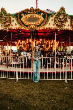 a woman standing in front of a merry go round