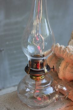 an old fashioned oil lamp sitting on top of a table