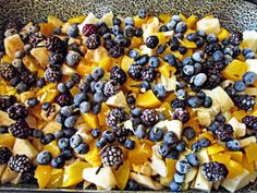 a pan filled with fruit and blueberries on top of a table