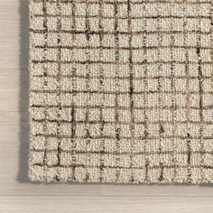 a beige and brown rug on top of a wooden floor