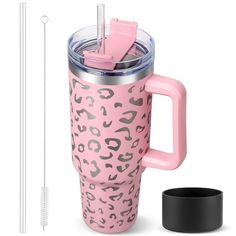 a pink leopard print travel mug next to a straw holder and cup with a straw in it