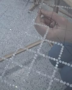 the reflection of someone's feet in a glass door with beads on it and a wooden stick