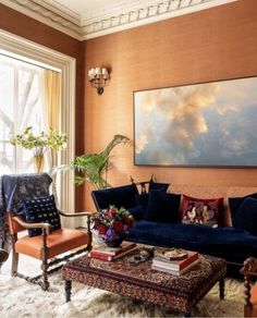 a living room filled with furniture and a large painting hanging on the wall above it