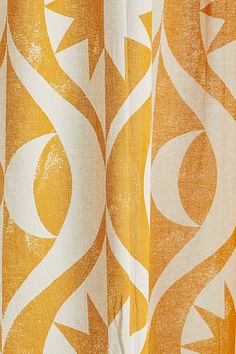 an orange and white curtain with swirls on it