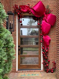 Front door Christmas bow decor red christmas door #christmasdecordiy Christmas Door Covering, Christmas Bow Door Decor, Over Door Christmas Decorations, Christmas Outdoor Door Decor, Christmas Decor Arch, Christmas Door Entrance Ideas, Christmas Front Door Bow, Bow Door Christmas, Christmas Decor At Home