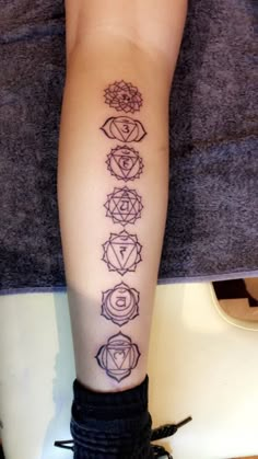 a person with a tattoo on their leg that has seven chakras in it