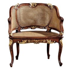 an ornately carved wooden chair with caned backrests and wicker upholstered seat