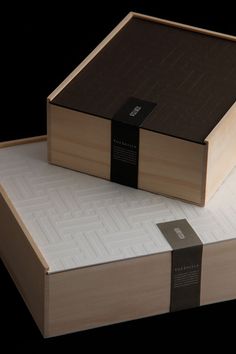 two wooden boxes sitting on top of each other with a black ribbon around the edges