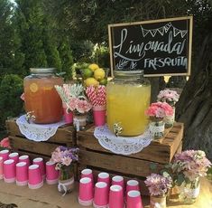 a table topped with mason jars filled with liquid and flowers on top of wooden pallets