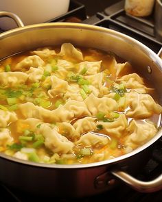 a pot filled with dumplings on top of a stove