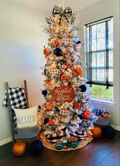 a white christmas tree with black and orange decorations