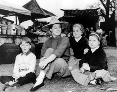 an old black and white photo of people sitting on the ground