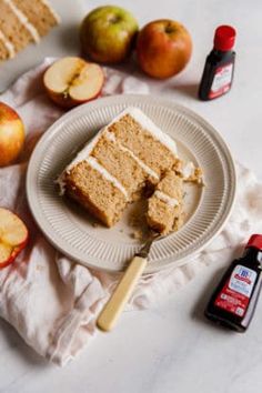 slices of cake sitting on top of a white plate next to apples and cinnamon sticks