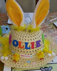 a hat with bunny ears and yellow feathers is on display at a children's birthday party