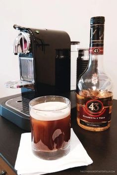 a bottle of alcohol next to a glass on a table