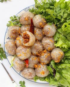 a white plate topped with meatballs covered in sauce and garnished with parsley