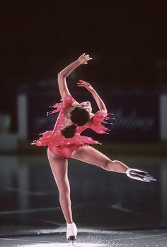 a female figure skating in a pink dress