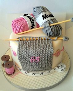 a cake decorated with yarn and knitting needles