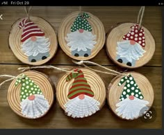 four christmas ornaments are hanging on wood slices