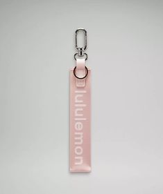 a pink keychain with the word'fun afternoon'printed on it, hanging from a metal hook