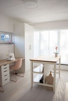 a room with a desk, chair and shelves on the wall next to a window