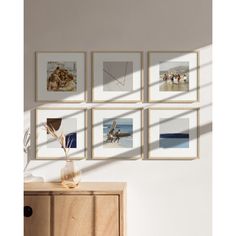 four framed photographs hang on the wall above a dresser in a room with white walls