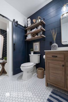 a white toilet sitting in a bathroom next to a wooden cabinet