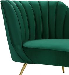 a green velvet chair with gold legs