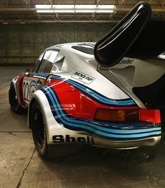 the rear end of a race car parked in a garage