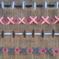 several different types of scissors on a piece of burlied fabric with pink and grey pins