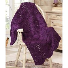 a purple blanket sitting on top of a white chair