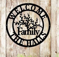 a metal sign that says welcome to the family tree on a wooden fence with grass