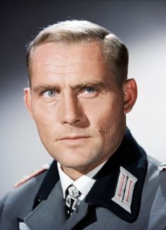 a man in uniform is looking at the camera with an intense look on his face