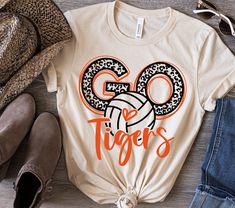 an orange and black shirt with the word go tigers on it next to some shoes