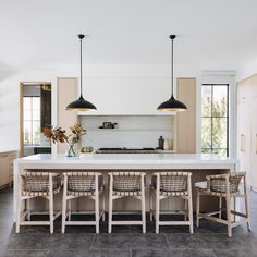 a kitchen with an island and chairs in it