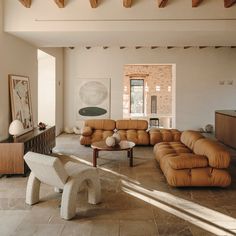 a living room filled with lots of furniture and decor on top of tile flooring