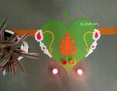 an overhead view of a decorative heart shaped decoration with candles and potted plant in the background