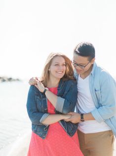 a man and woman hugging on the beach