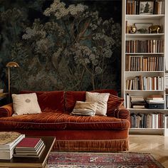 a living room with bookshelves and a couch in front of a painting on the wall