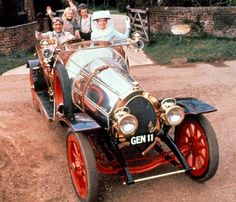 an old fashioned car with people in the back