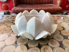 a white lotus flower sitting on top of a table next to a brown leather couch