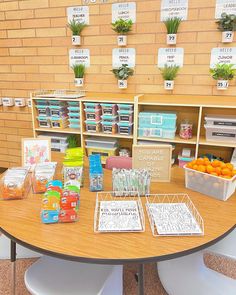 a table with several trays of fruit and vegetables on it in front of shelves