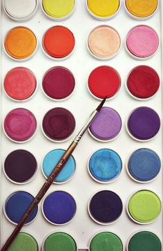 an artist's palette with paint and a brush