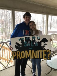 a man and woman holding up a sign